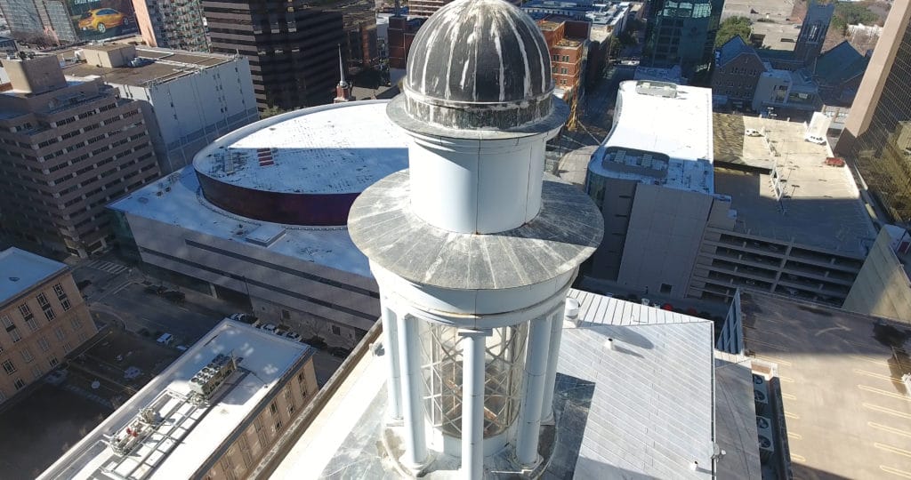 Visually inspecting an older building with a drone.