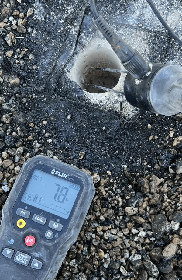 Examining moisture content of a roof through core samples.