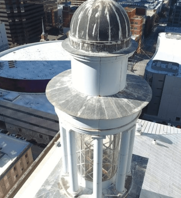 Visually inspecting an older building with a drone.